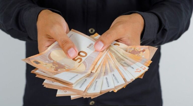 Osoba u tamnoj košulji drži u rukama raširene novčanice od 50 evra